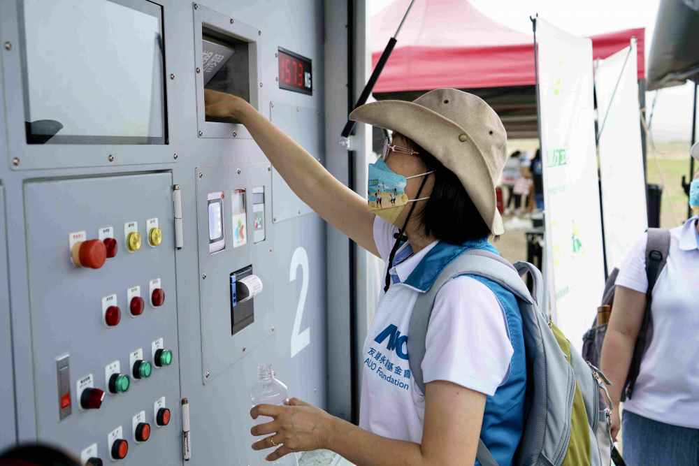 志工們將拾起的寶特瓶投入「好歸塑專車」，讓廢棄塑料空瓶可以直接粉碎、縮小體積，未來將可再製成購物袋、寶特衣、悠遊卡等生活用品